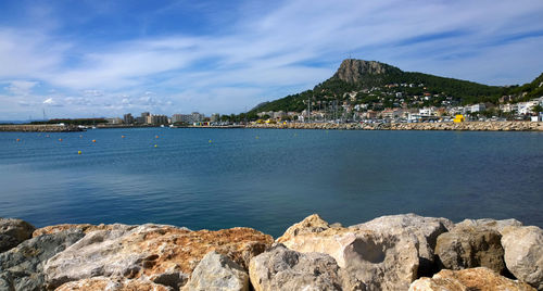 Scenic view of sea by city against sky