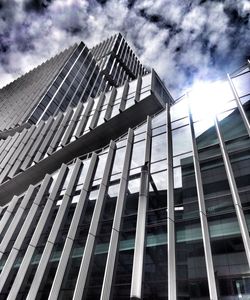 Low angle view of modern building against cloudy sky