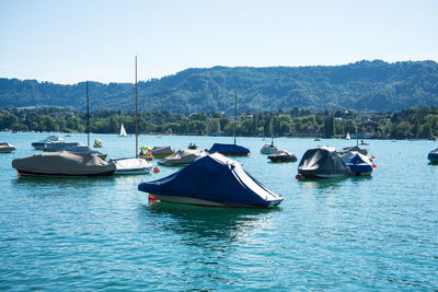 Boats moored in lake against sky