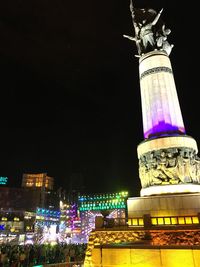 Low angle view of illuminated building against sky at night