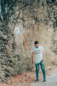 Portrait of young man standing in forest