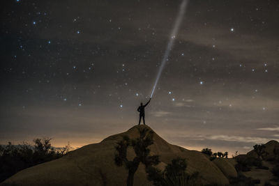 Low angle view of person on landscape against sky at night