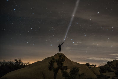 Man holding flashlight at night