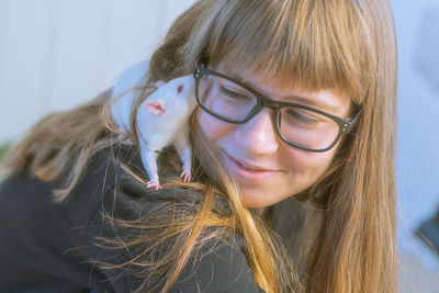 Close-up of smiling girl with rat