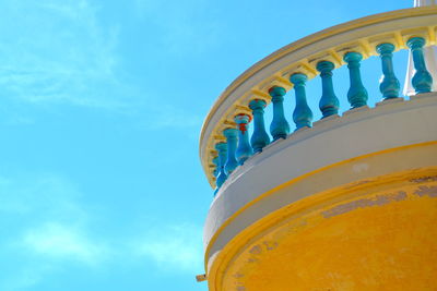 Low angle view of balcony railing against blue sky