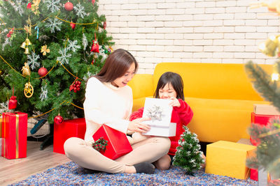 Young woman sitting by christmas decorations