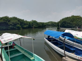 Boats moored in lake against sky