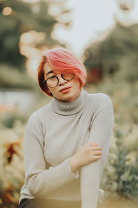 Young woman wearing eyeglasses at park during sunset