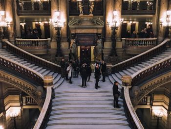 High angle view of people standing on steps in illuminated building