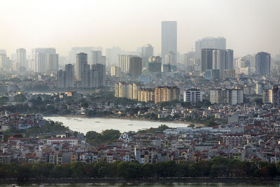 Aerial view of buildings in city against sky