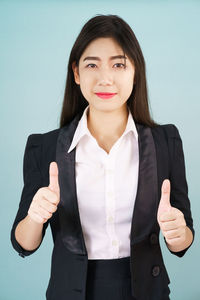 Portrait of a smiling young woman against gray background