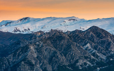 Scenic view of snowcapped mountains against sky during sunset