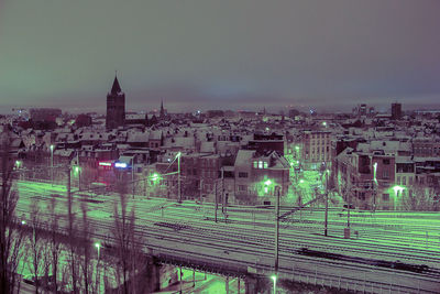 Illuminated cityscape against sky at night