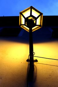 Close-up of illuminated lamp against clear sky at night