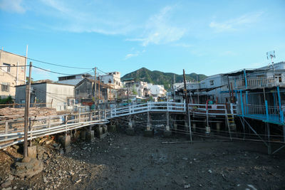 Bridge over river amidst buildings against blue sky