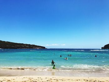 People at beach against sky