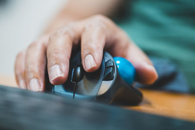 Close-up of woman hand using computer mouse at desk