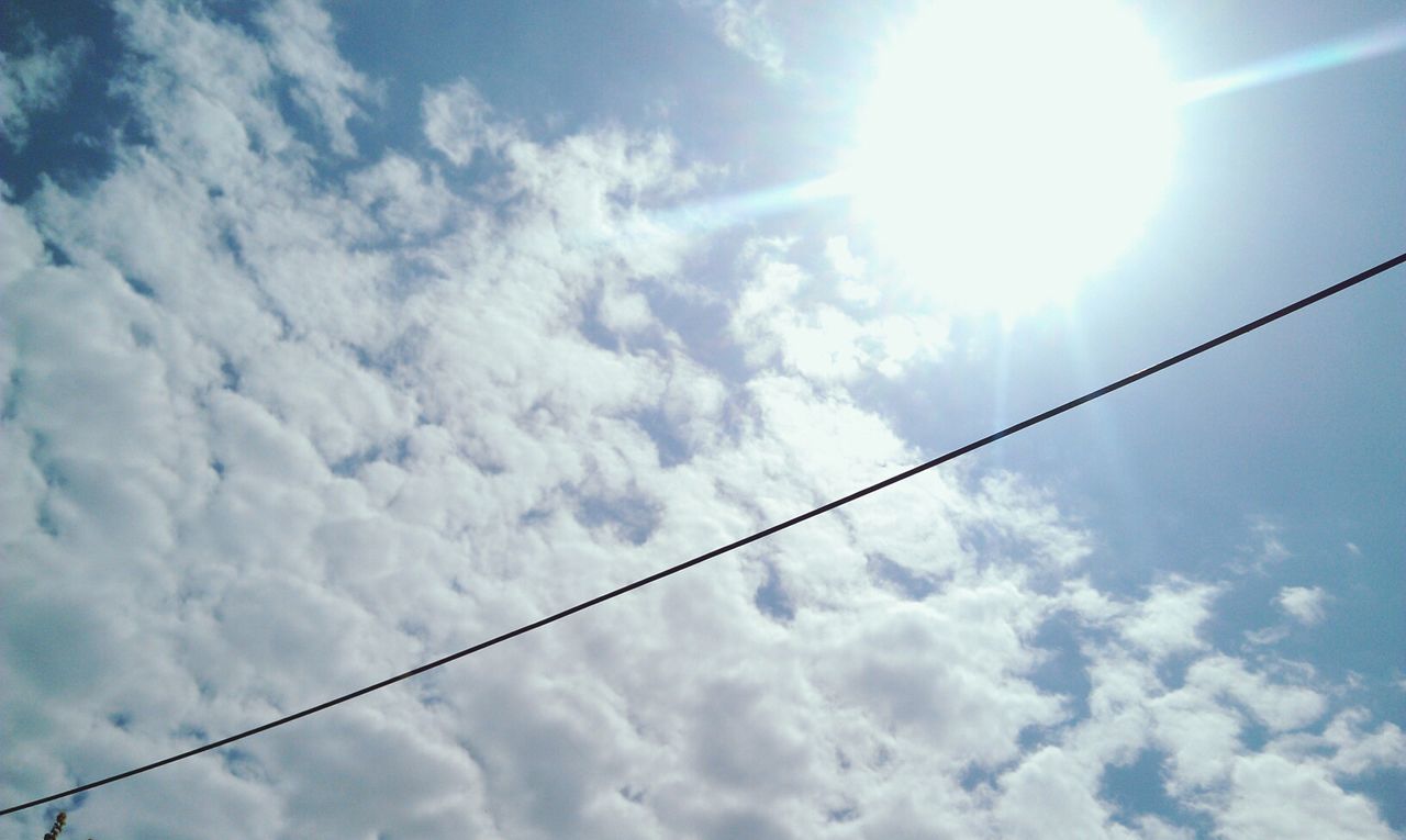 low angle view, sky, cloud - sky, power line, cloudy, cable, cloud, sun, electricity, nature, blue, tranquility, beauty in nature, sunlight, sunbeam, power supply, outdoors, day, connection, no people