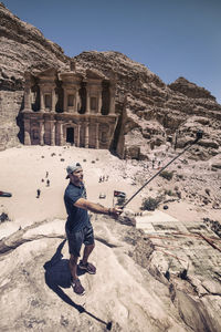 Man taking selfie while standing on rock formation