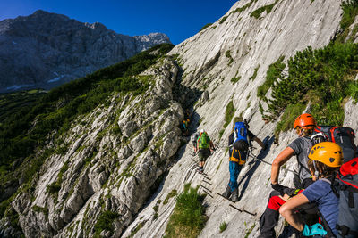 Group of people on rock against mountain range