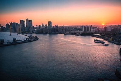 Scenic view of sea and buildings against sky during sunset