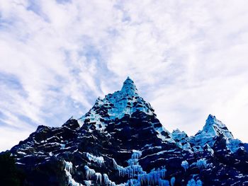 Low angle view of snow mountains against sky