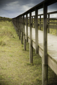 Wooden posts on field against sky