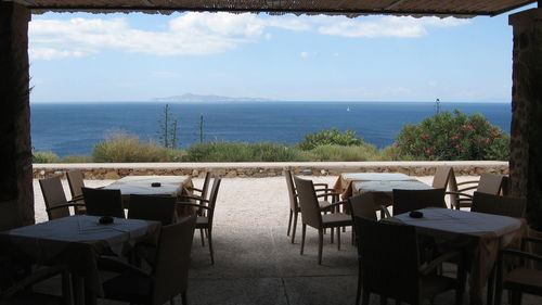 Empty chairs and tables at seaside