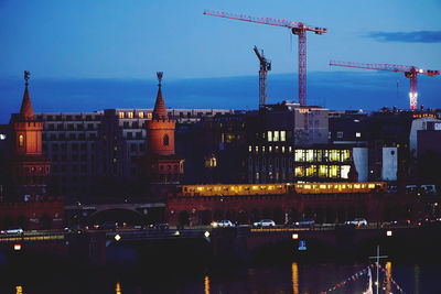 Illuminated buildings against sky at dusk