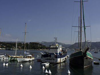 Sailboats moored at harbor