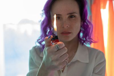 Portrait of young woman holding smart phone outdoors