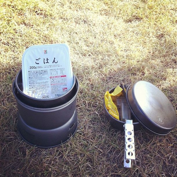 high angle view, grass, text, field, communication, western script, still life, abandoned, day, no people, number, close-up, outdoors, grassy, dirt, variation, obsolete, container, directly above, plastic