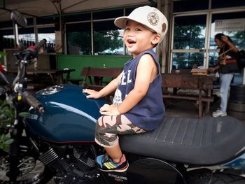 Smiling boy sitting on motorcycle