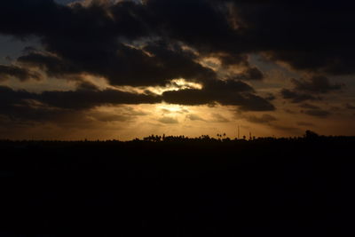 Silhouette landscape against sky during sunrise