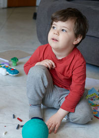 Cute young boy playing with toys in the livingroom