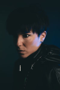 Close-up portrait of young man against black background