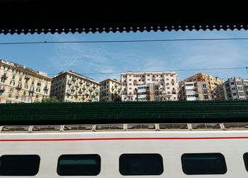 Low angle view of train and buildings against sky