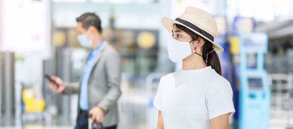 Side view of woman standing against blurred background