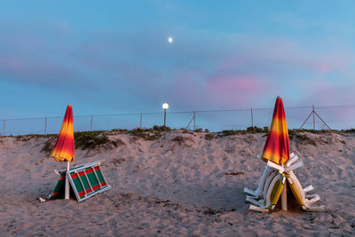 Lifeguard chair on beach against sky