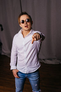 Portrait of young man wearing sunglasses standing at home