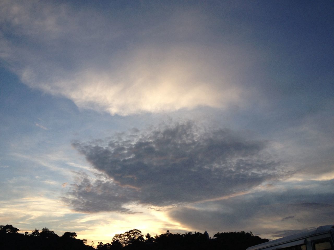 sky, low angle view, cloud - sky, silhouette, tree, beauty in nature, sunset, scenics, tranquility, nature, cloudy, cloud, tranquil scene, idyllic, outdoors, no people, high section, built structure, cloudscape, dramatic sky