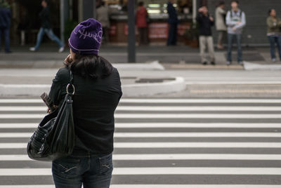 Rear view of woman walking on road