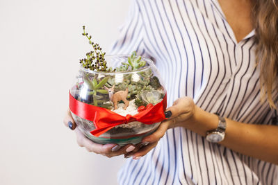 Midsection of woman holding food against white background