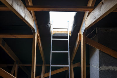 An open roof hatch in the attic for a chimney sweep, a standing ladder in the window.