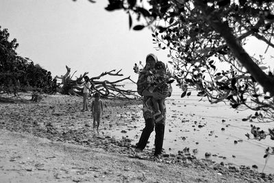 Full length of woman standing on tree trunk