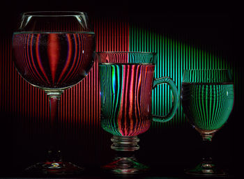 Red wine glass on table against black background