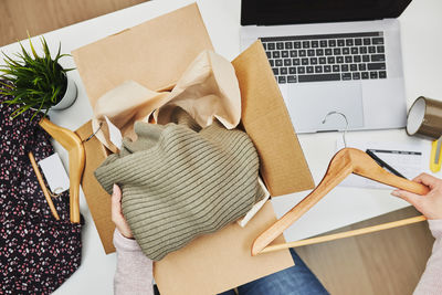 Business owner packing online order to delivery to customer. preparing parcel box with clothes