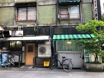 Bicycle parked on street by building