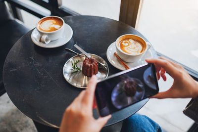 Midsection of man holding coffee cup