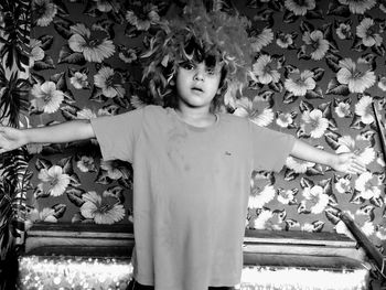 Portrait of girl standing by flowering plants